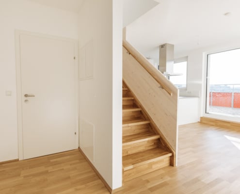 Hier ist der Wohnbereich mit Treppe nach oben. Im Hintergrund sieht man den Dunstabzug der Küche.