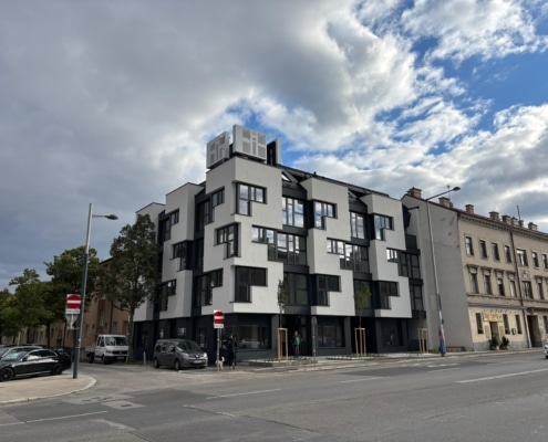 Hier sieht man einen Neubau eines Hauses. Im Straßenverlauf ist rechts ein Altbau zu sehen.