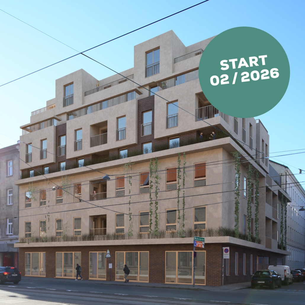 Hier sieht man ein Haus mit beiger und teilweise brauner Fassade. Davor gehen Menschen und in der Seitenstraße stehen Autos.