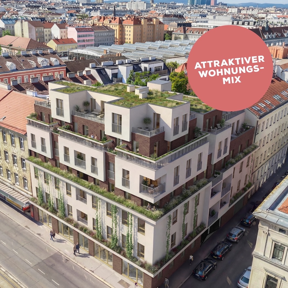 Man sieht ein saniertes Haus mit heller Fassade und braunen Elementen. Das Dach ist begrünt.