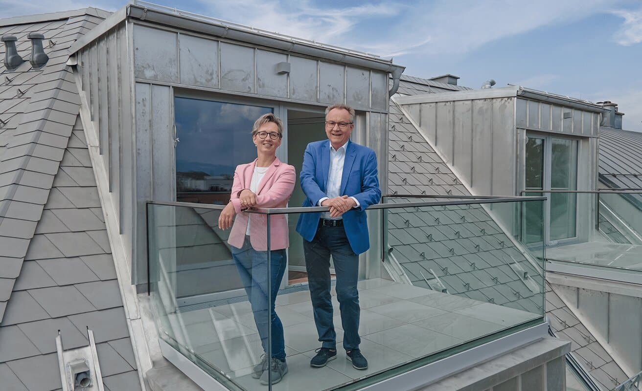 Eine Frau und ein Mann stehen auf einem Balkon Eine Frau und ein Mann stehen auf einem Balkon